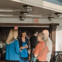 President Mantella talks to older couple and women while holding glasses